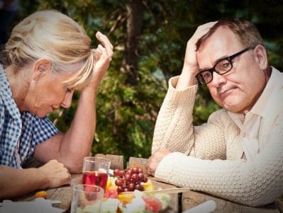 Older man and woman looking unhappy
